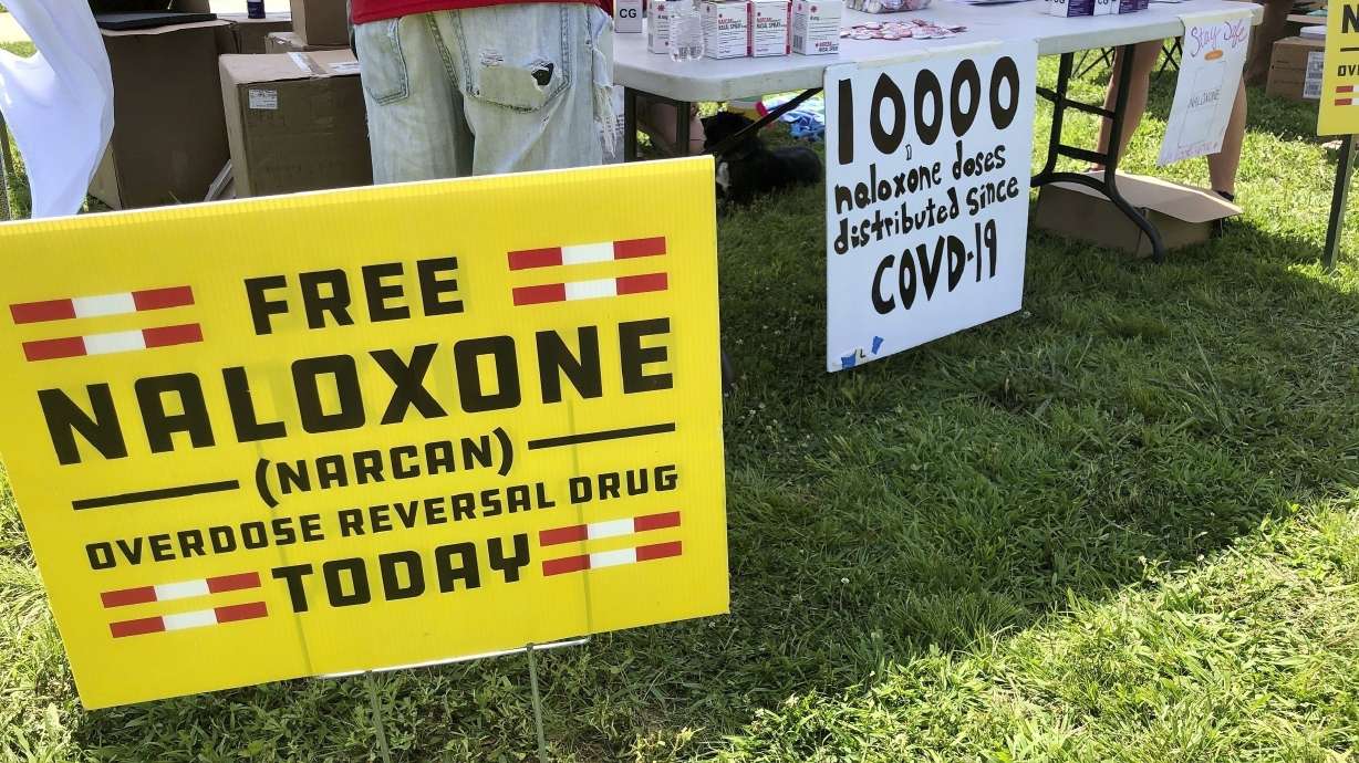 Signs are displayed at a tent during a health event on June 26, 2021, in Charleston, W.Va. The CDC reports overdose deaths fell 27% last year.