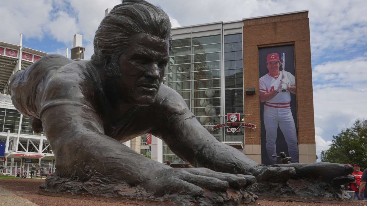 A bronze statue and a banner of former Cincinnati Reds player Pete Rose are seen outside the Great American Ball Park, Tuesday, May 13, 2025, in Cincinnati.