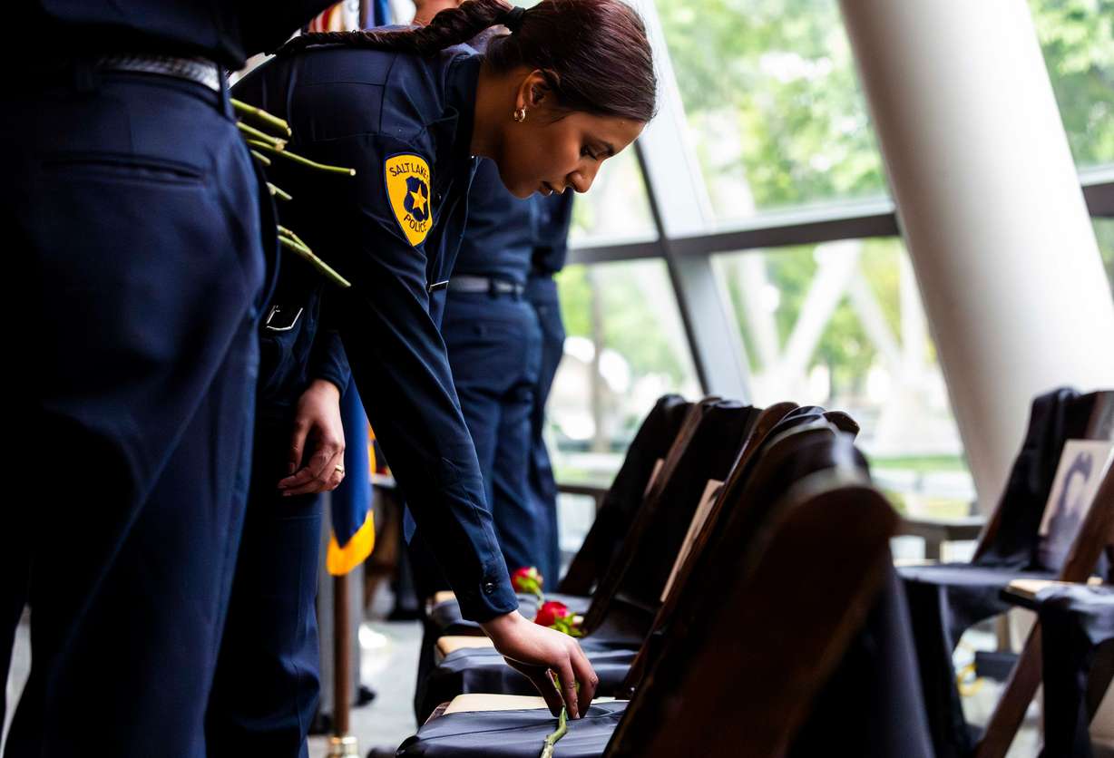 Cadet Qunoot Albidani lays a rose on a chair for a fallen Salt Lake City police officer at a ceremony to honor the lives of the 25 police officers who have died in the line of duty throughout the Salt Lake City Police Department’s history, at the Public Safety Building in Salt Lake City on Wednesday.