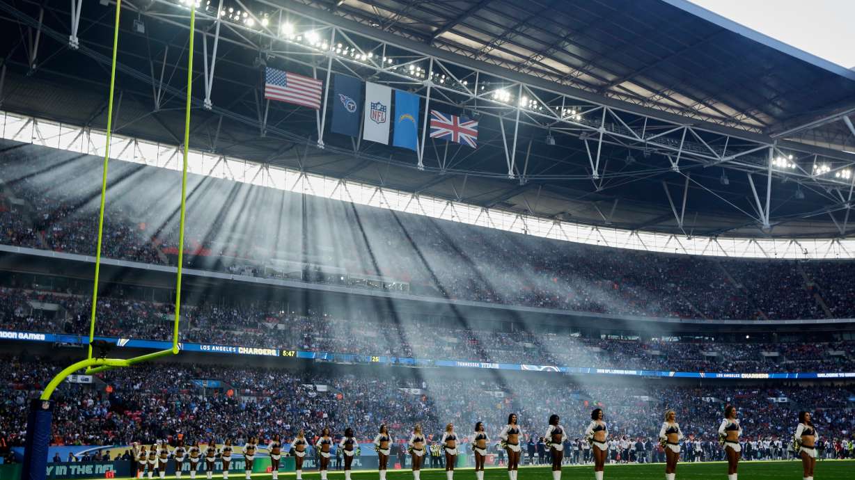 FILE - Sun filters through the stadium as cheerleaders line up before an NFL football game between Tennessee Titans and Los Angeles Chargers at Wembley stadium in London, Sunday, Oct. 21, 2018.