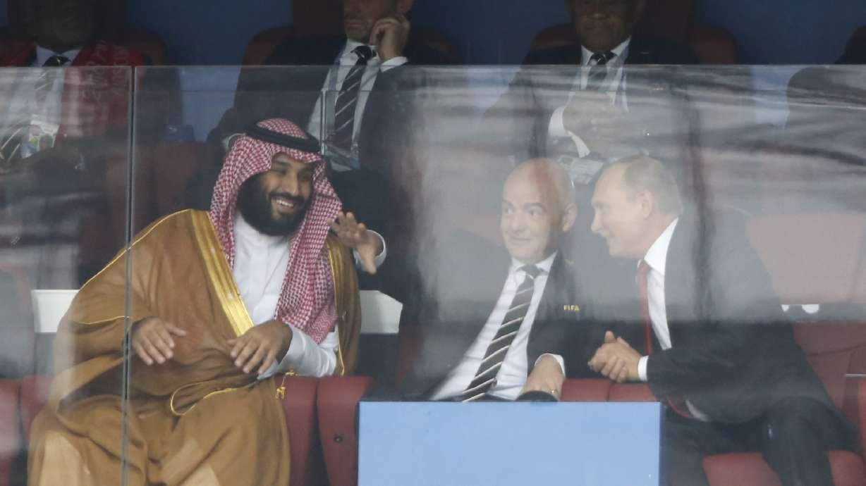 FILE - Saudi Arabia Crown Prince Mohammed bin Salman, left, FIFA President Gianni Infantino, center, and Russian President Vladimir Putin watch the match between Russia and Saudi Arabia which opens the 2018 soccer World Cup at the Luzhniki stadium in Moscow, Russia, on June 14, 2018.