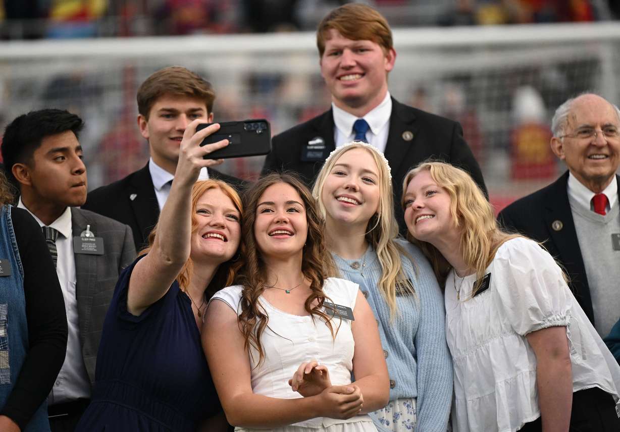 Missionaries from The Church of Jesus Christ of Latter-day Saints take photos of themselves as they wait to sing the national anthem prior to Real Salt Lake and the Portland Timbers playing at America First Field in Sandy on Wednesday.