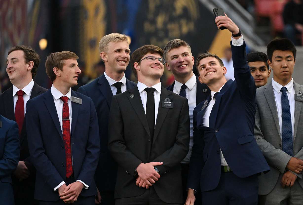 Missionaries from The Church of Jesus Christ of Latter-day Saints take photos of themselves as they wait to sing the national anthem prior to Real Salt Lake and the Portland Timbers playing at America First Field in Sandy on Wednesday.