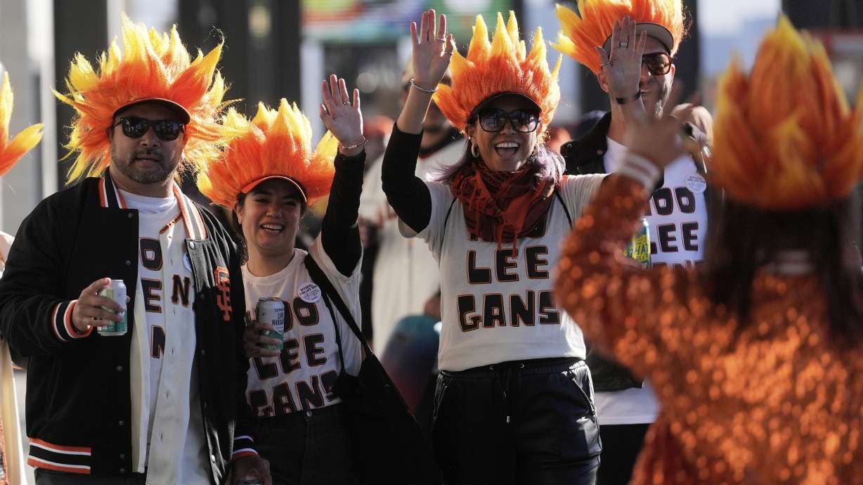 Fans of San Francisco Giants' Jung Hoo Lee, who call themselves Hoo Lee Gans, greet fellow fans as they arrive before a baseball game between the Giants and the Arizona Diamondbacks in San Francisco, Tuesday, May 13, 2025.
