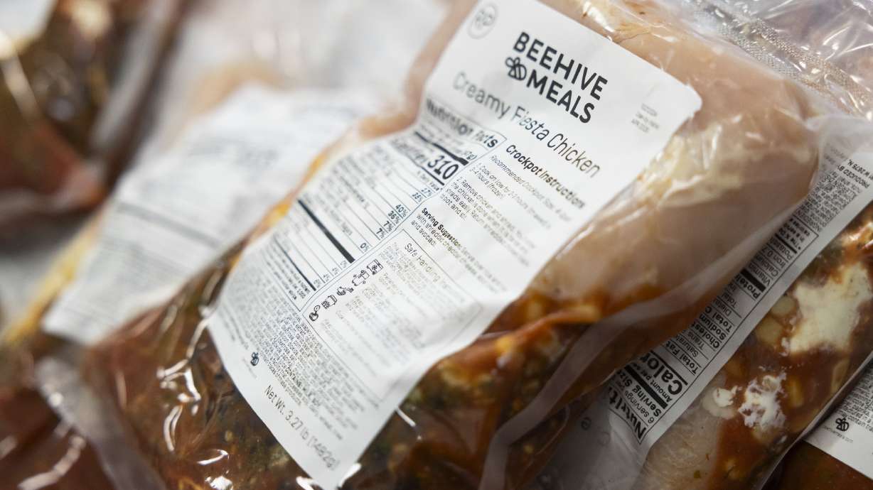 Packages of Beehive Meals’ Creamy Fiesta Chicken sit in a pile after being prepared by workers at the Beehive Meals kitchen in Layton on Oct. 21, 2024. Beehive Meals on Thursday announced a new, meat-focused offering.