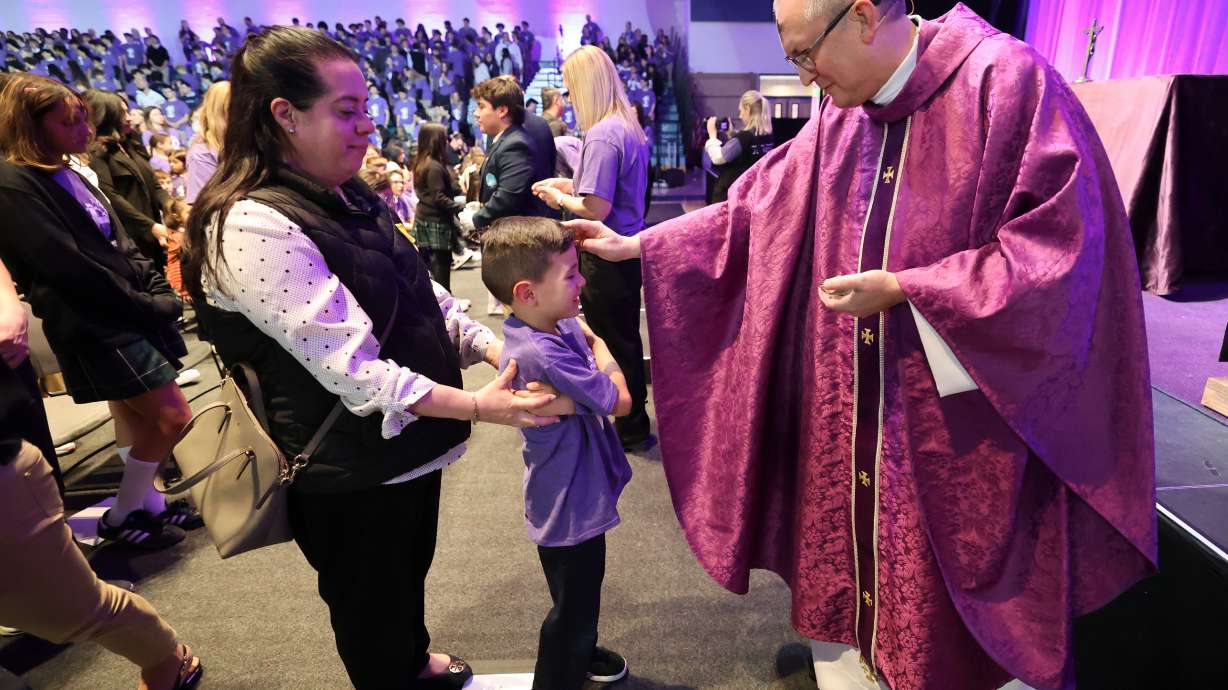 Carmen Wursten accompanies her son Sebastian Wursten as he receives ashes from the Very Reverend John S. Evans on Ash Wednesday Mass with students in Draper on March 5. A judge ruled on issues facing the Utah Fits All Scholarship program.