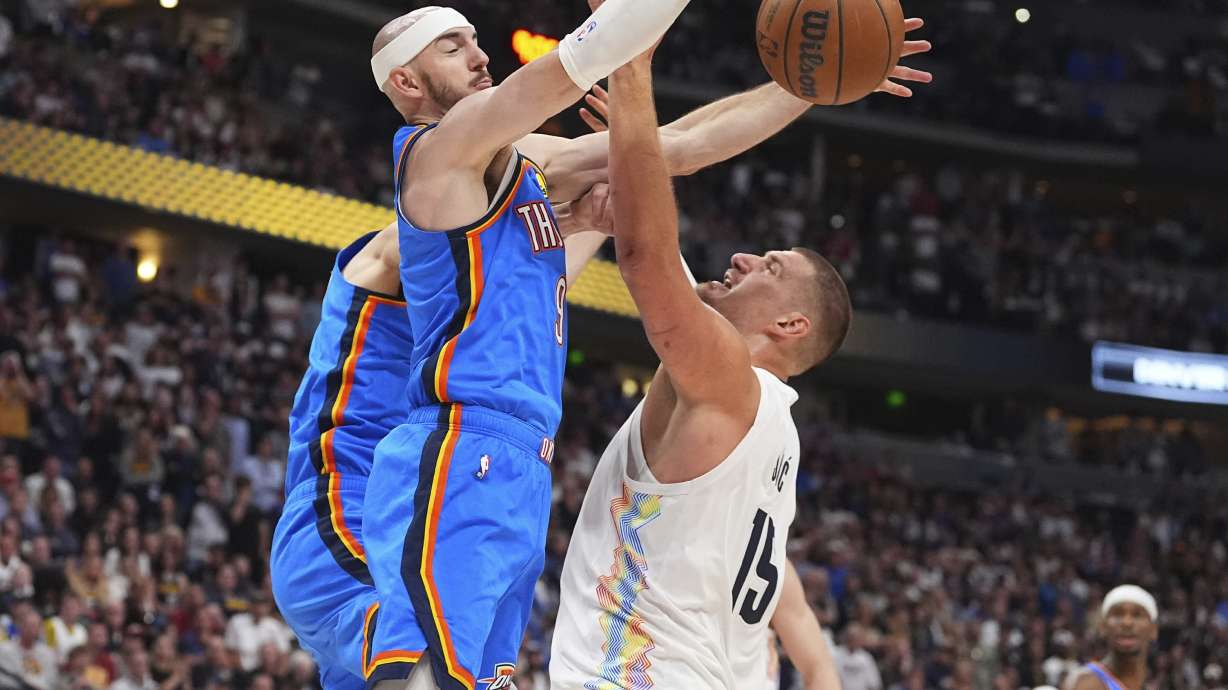 Oklahoma City Thunder guard Alex Caruso, left, blocks a shto by Denver Nuggets center Nikola Jokic in the second half of Game 6 in the Western Conference semifinals of the NBA basketball playoffs Thursday, May 15, 2025, in Denver.