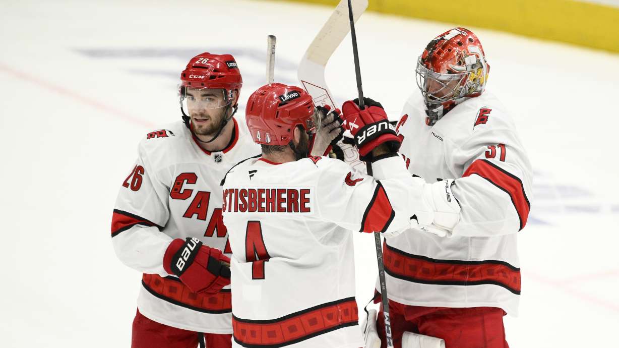 Carolina Hurricanes goaltender Frederik Andersen, right, celebrates with defenseman Shayne Gostisbehere (4) and defenseman Sean Walker (26) after Game 5 of a second-round NHL hockey playoff series against the Washington Capitals Thursday, May 15, 2025, in Washington.