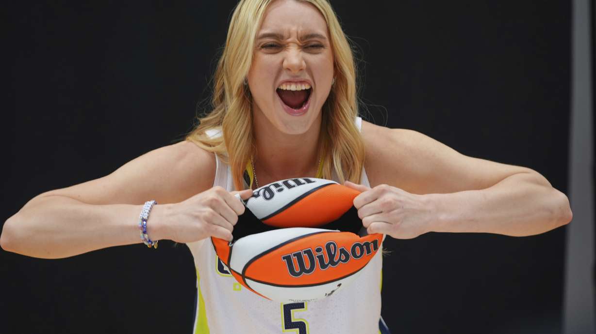 Dallas Wings guard Paige Bueckers (5) poses for photos during a WNBA basketball media day in Arlington, Texas, Wednesday, May 7, 2025.