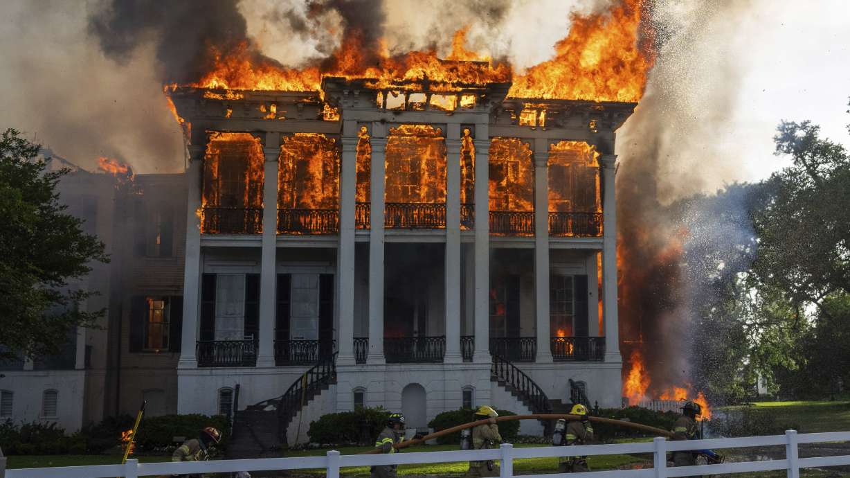 Fire crews move a line around the now fully engulfed the Nottoway Plantation on Thursday in White Castle, La.