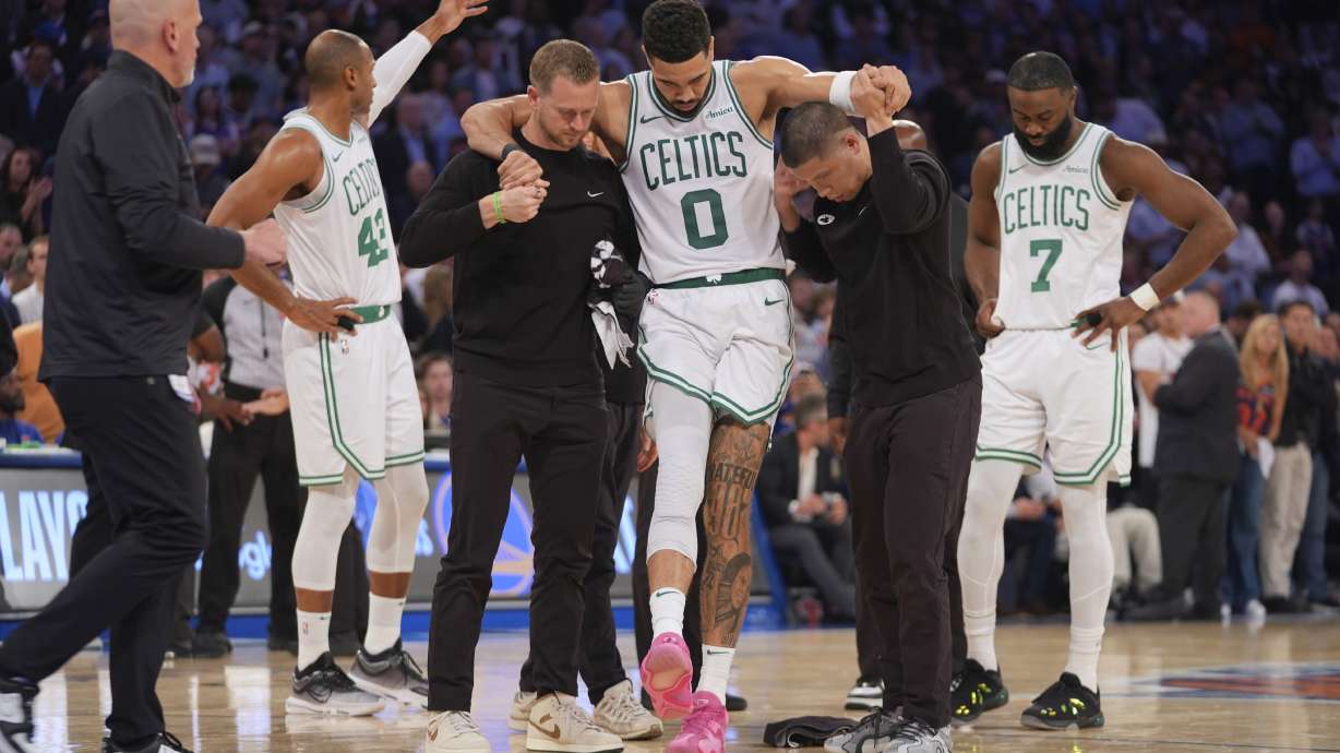 Trainers help Boston Celtics' Jayson Tatum (0) off the court after he was injured during the second half of Game 4 in the Eastern Conference semifinals of the NBA basketball playoffs against the New York Knicks Monday, May 12, 2025, in New York.