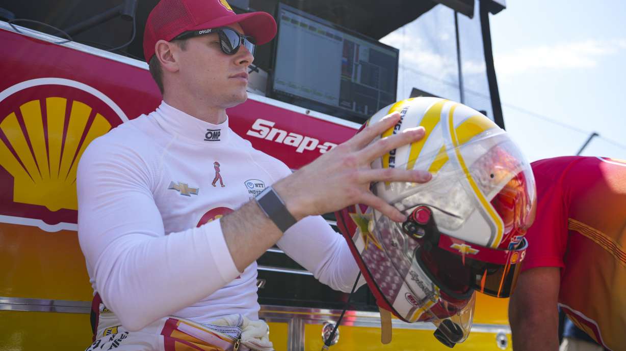Josef Newgarden checks his helmet as he waits for the start of practice for the Indianapolis 500 auto race at Indianapolis Motor Speedway in Indianapolis, Friday, May 16, 2025.