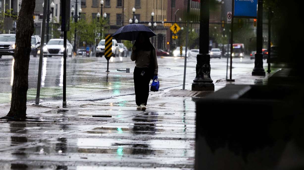 Mabel Chang walks to work while it rains in Salt Lake City on April 30. Valley rain and thunderstorms are in Utah's forecast this weekend, along with potentially heavy mountain snow.