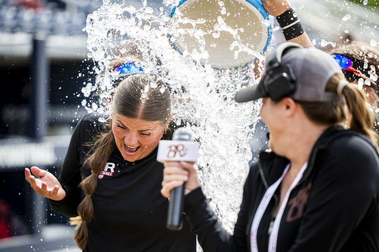 Bear River coach Jordan Theurer is doused with water by her players after defeating Desert Hills in extra innings during the final game of the championship series in the 4A high school softball state tournament held at Gail Miller Field in Provo on Friday, May 16, 2025. Bear River won the game 3-2 in eight innings, and the series 2-1.