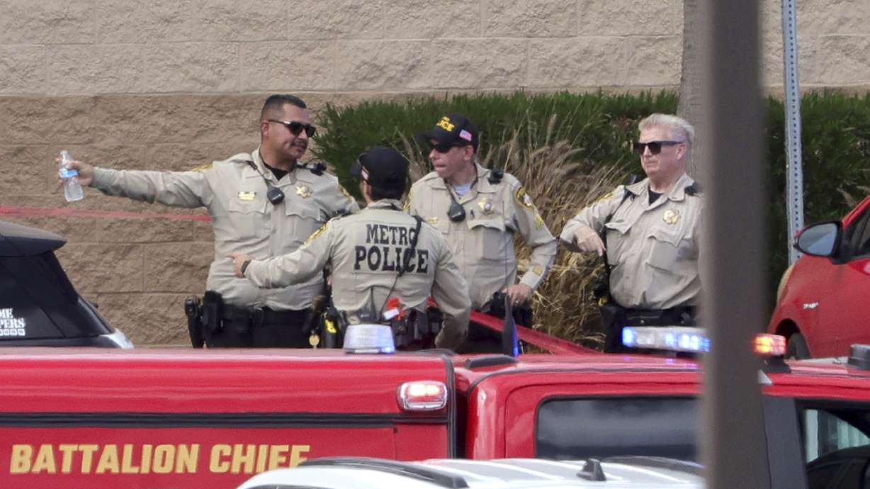 Las Vegas Metro Police officers confer by the main entrance of the Las Vegas Athletic Club after a shooting Friday.