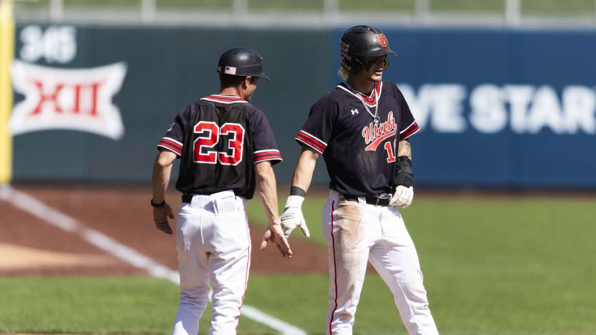 Utah infielder Core Jackson (10) celebrates stealing third with third base coach Mike Brown during a college baseball game between Utah and BYU at Smith's Ballpark in Salt Lake City on Saturday, April 12, 2025. Utah won the game with a final score of 9-6.