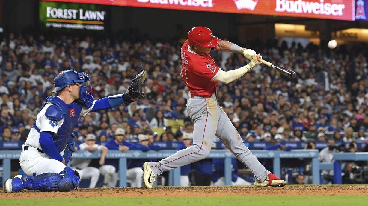 Los Angeles Angels' Logan O'Hoppe, hits a three-run home run as Los Angeles Dodgers catcher Dalton Rushing watches during the seventh inning of a baseball game Saturday, May 17, 2025, in Los Angeles.