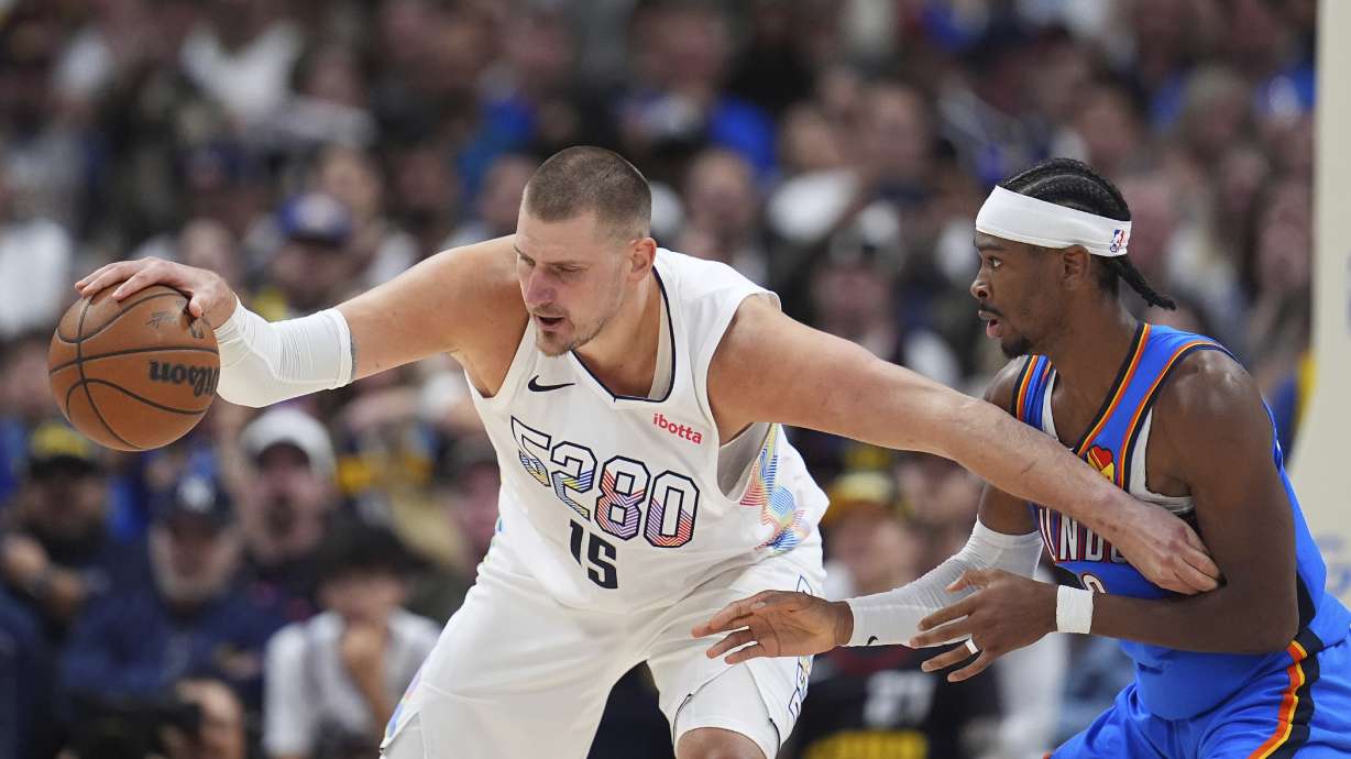 Denver Nuggets center Nikola Jokic, left, struggles to control the ball as Oklahoma City Thunder guard Shai Gilgeous-Alexander defends in the second half of Game 6 in the Western Conference semifinals of the NBA basketball playoffs Thursday, May 15, 2025, in Denver.