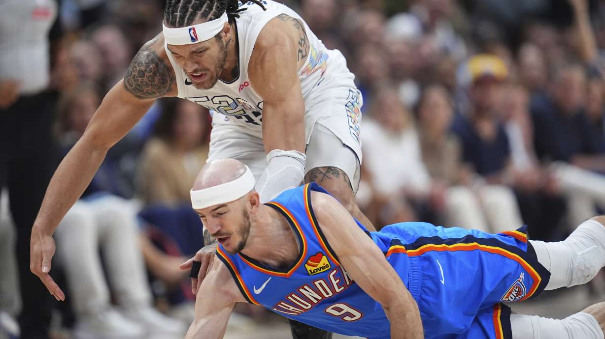 Oklahoma City Thunder guard Alex Caruso, front, dives for a loose ball in front of Denver Nuggets forward Aaron Gordon in the second half of Game 6 in the Western Conference semifinals of the NBA basketball playoffs Thursday, May 15, 2025, in Denver.
