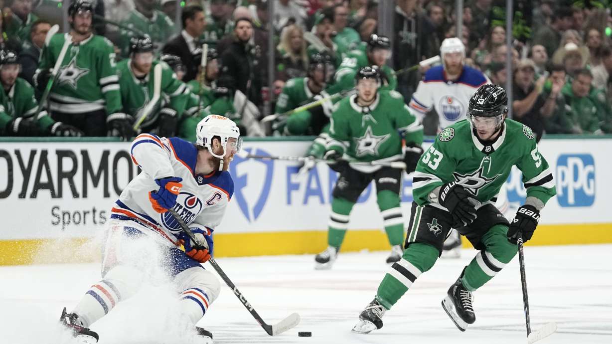 FILE - Edmonton Oilers center Connor McDavid (97) works to get the puck past Dallas Stars center Wyatt Johnston (53) during the first period of Game 1 of the Western Conference finals in the NHL hockey Stanley Cup playoffs, May 23, 2024, in Dallas.
