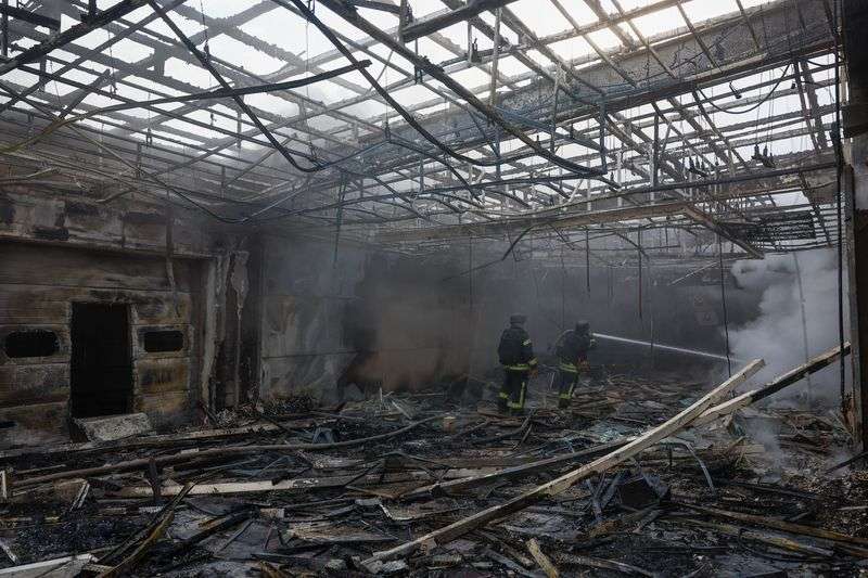 Firefighters work at the site of a private enterprise hit by a Russian drone strike, amid Russia's attack on Ukraine, outside of Kyiv, Ukraine on Sunday.