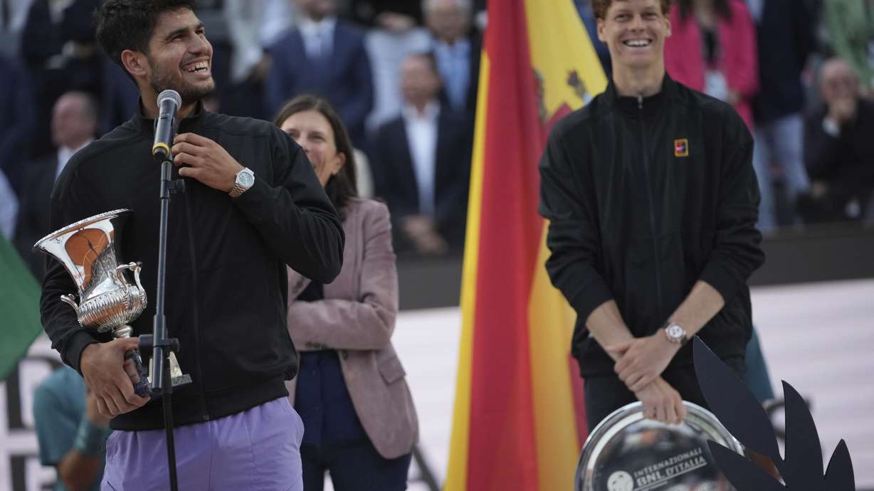 Carlos Alcaraz of Spain, holds the trophy after winning the Italian Open tennis tournament next to Jannik Sinner of Italy at the Foro Italico in Rome, Sunday, May 18, 2025.