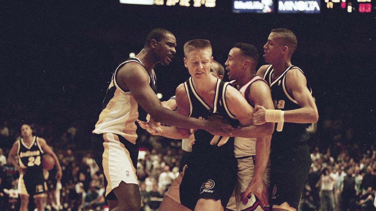 FILE - Indiana Pacers' Detlef Schrempf, center, is restrained by teammate LaSalle Thompson, left, as New York Knicks' John Starks, second from right, is sandwiched between the Pacers' Reggie Miller during a third period scuffle that began when Schrempf clashed with Knicks' Anthony Mason in New York's Madison Square Garden, March 15, 1993. The Knicks went on to a 121-90 win.