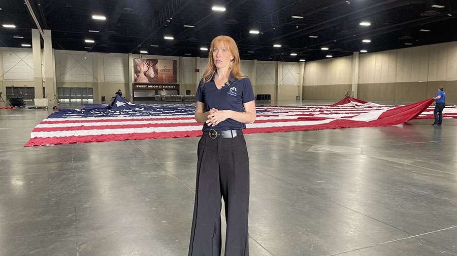 Jennie Taylor speaks about the damaged flag and replacing it as it’s been laid out in the Mountain America Exposition Center in Sandy on Monday.