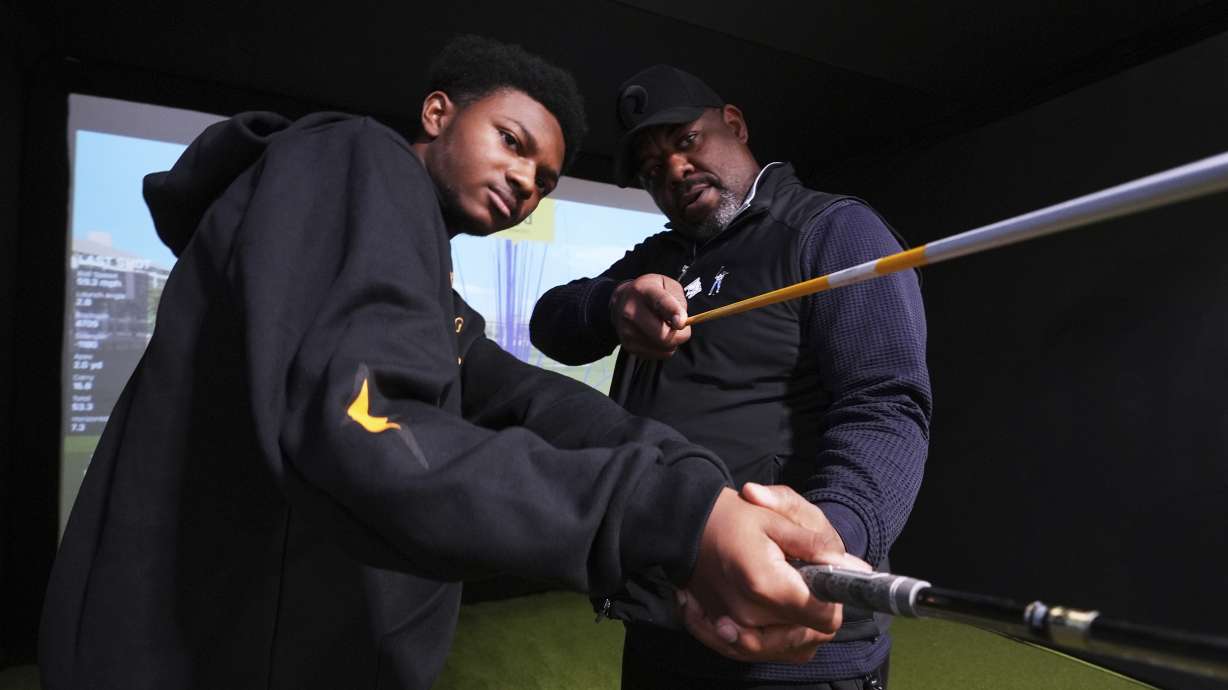 Shaun Horne, 16, a junior at Renaissance High School works on his swing with golf coach Jess Hawkins in Detroit, Thursday, Feb. 27, 2025.