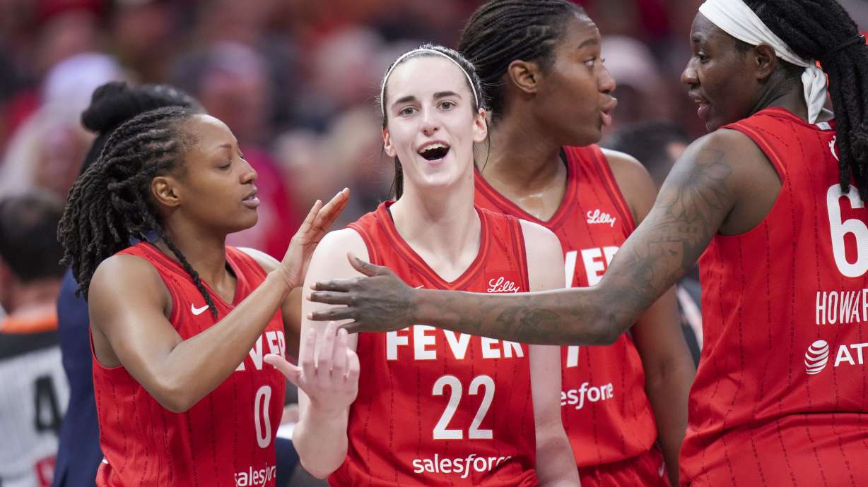Indiana Fever guard Caitlin Clark (22) is ushered back to the bench area by teammates after being called for a flagrant foul on Chicago Sky forward Angel Reese during the second half an WNBA basketball game in Indianapolis, Saturday, May 17, 2025.