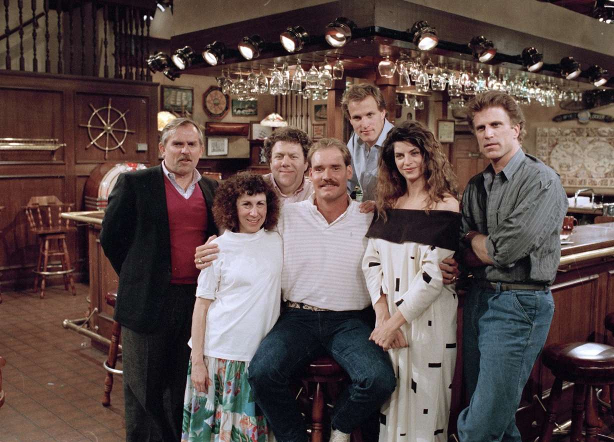 Boston Red Sox third baseman Wade Boggs, center, poses, March 2, 1988, with the cast of "Cheers" during rehearsal for an episode in which he appears. Cast members include John Ratzenberger, Rhea Perlman, George Wendt, Woody Harrelson, Kirstie Alley and Ted Danson.