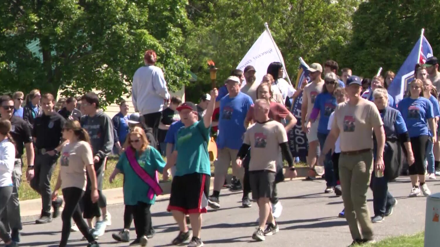 A crowd of athletes and officers follow behind the Special Olympics torch on Tuesday.