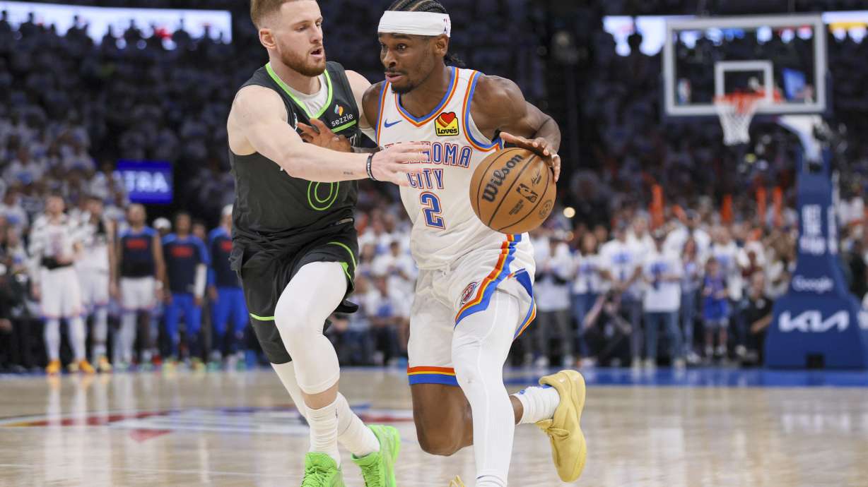 Oklahoma City Thunder guard Shai Gilgeous-Alexander (2) drives against Minnesota Timberwolves guard Donte DiVincenzo (0) during the second half of Game 1 of an NBA basketball Western Conference Finals playoff series Tuesday, May 20, 2025, in Oklahoma City.