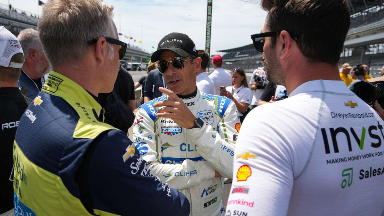 Helio Castroneves, of Brazil, center talks with Ed Carpenter, left, and Jack Harvey, of the United Kingdom, as the drivers gather for a photo before the start of practice for the Indianapolis 500 auto race at the Indianapolis Motor Speedway in Indianapolis, Monday, May 19, 2025.