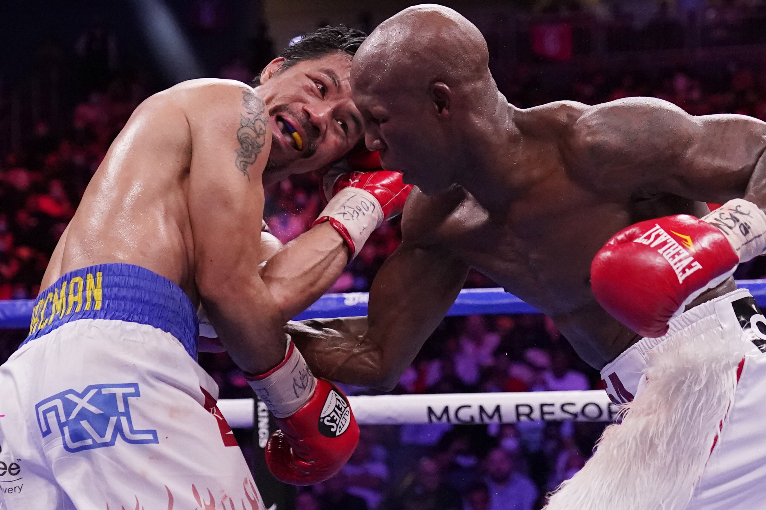 FILE - Yordenis Ugas, right, of Cuba, punches Manny Pacquiao, of the Philippines, during a welterweight championship boxing match Saturday, Aug. 21, 2021, in Las Vegas.