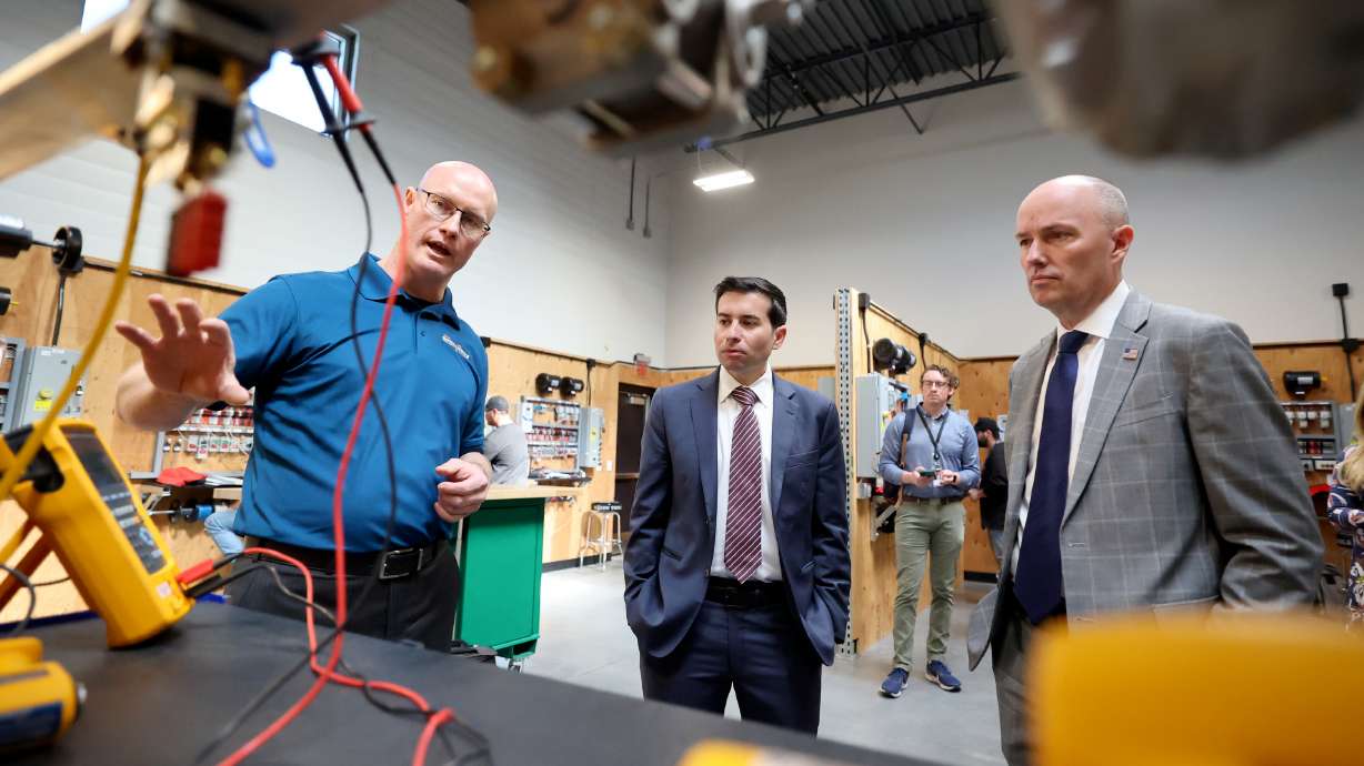 Utah Electrical Training Alliance instructor Clayton Cornia shows Gov. Spencer Cox and U.S. Deputy Secretary of Labor Keith E. Sonderling different features of training stations while visiting Utah Electrical Training Alliance in West Jordan on Wednesday.