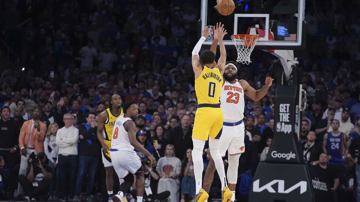 Indiana Pacers guard Tyrese Haliburton (0) shoots a 2-point shot against New York Knicks center Mitchell Robinson (23) to tie the score at the end of regulation in Game 1 of the NBA basketball Eastern Conference final, Wednesday, May 21, 2025, in New York.