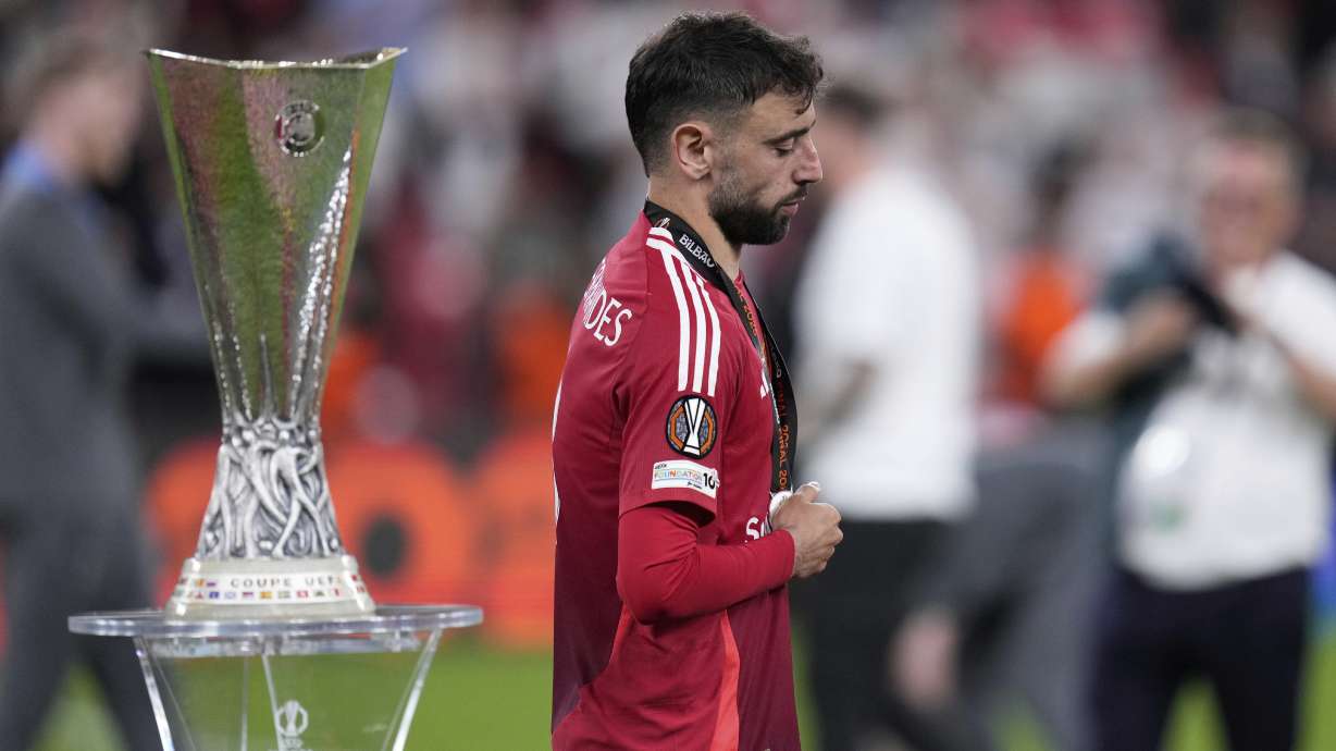Manchester United's Bruno Fernandes walks past the trophy at the end of the Europa League final soccer match between Tottenham Hotspur and Manchester United at the San Mames Stadium in Bilbao, Spain, Wednesday, May 21, 2025.