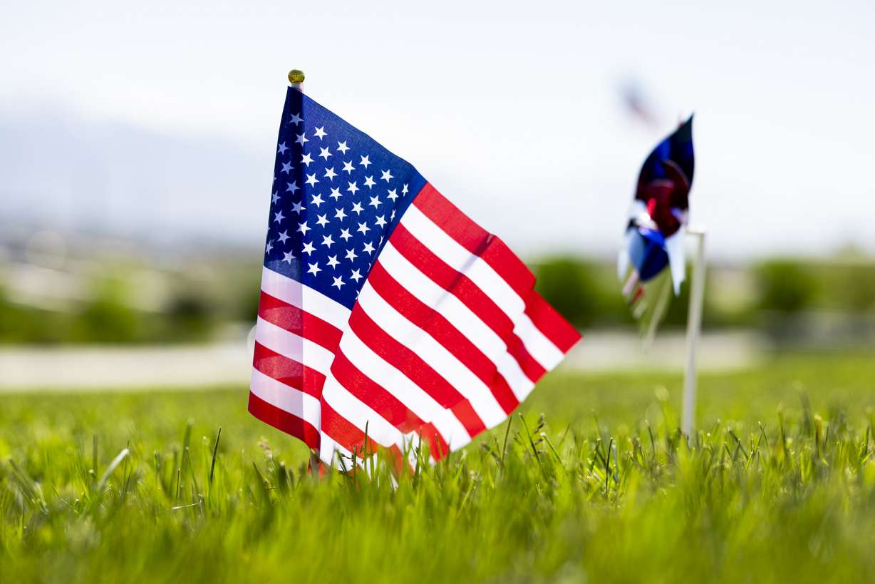 An American flag is posted at a grave at the Utah Veterans Cemetery and Memorial Park in Bluffdale on Wednesday.