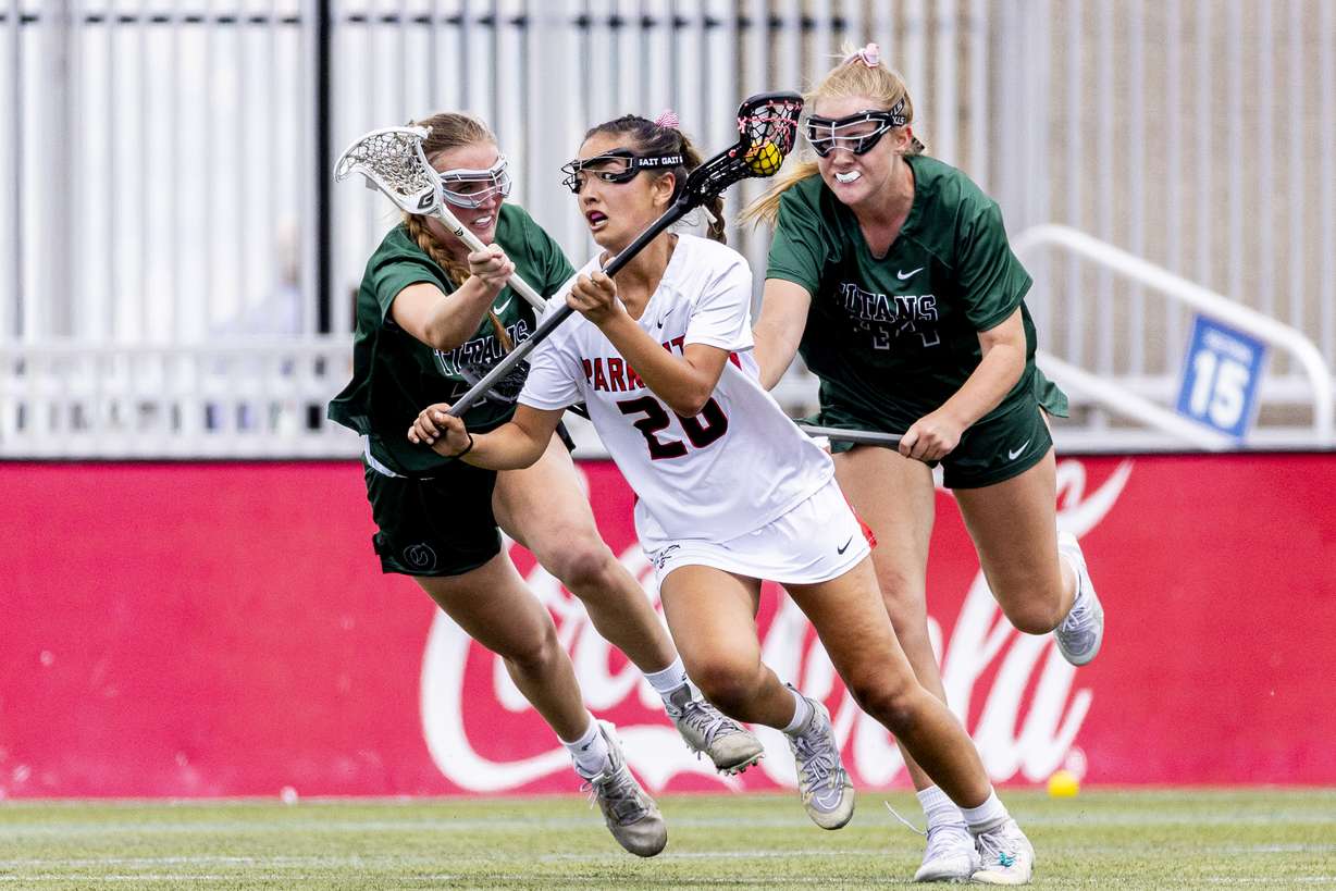 Park City midfielder Sophia Mondschein (26) controls the ball while guarded by Olympus defenders Madeline Alfandre, left, and Caroline Harmer (44) during the championship game of the 5A high school girls lacrosse state tournament held at Zions Bank Stadium in Herriman on Thursday, May 22, 2025.