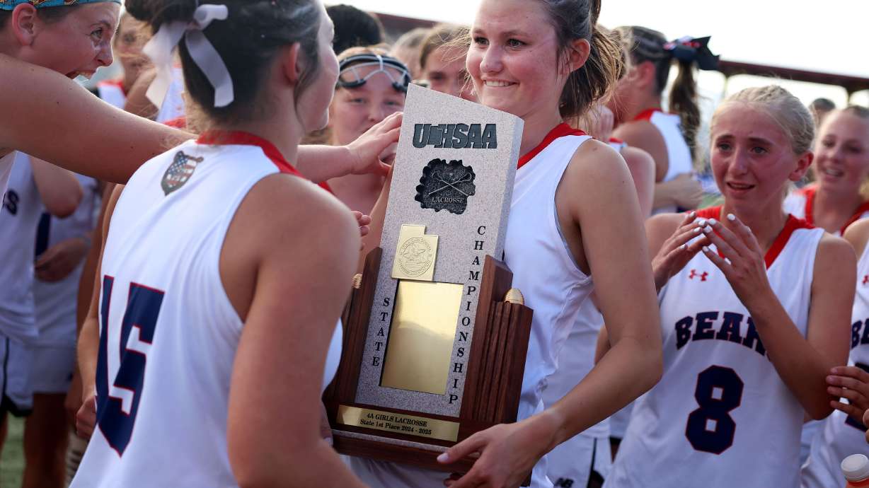 Bear River’s girls lacrosse players gather around their trophy after winning the 4A girls lacrosse state championship game against Waterford at Zions Bank Stadium in Herriman on Thursday, May 22, 2025.