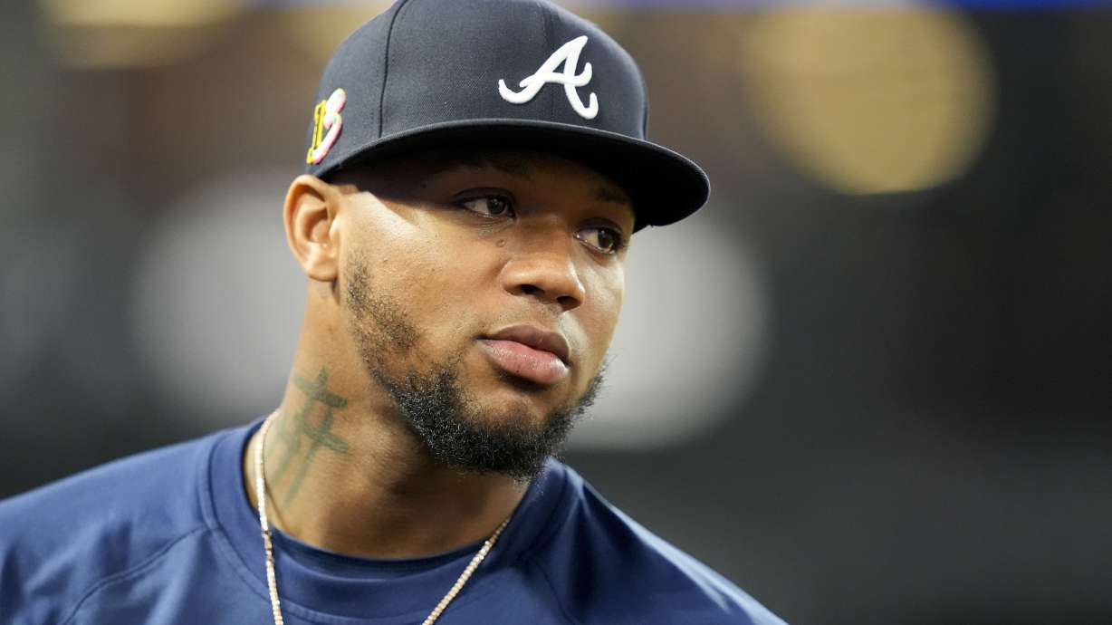 FILE - Atlanta Braves' Ronald Acuna Jr. stands in the dugout during the fifth inning of a baseball game against the Los Angeles Angels, on Aug. 17, 2024, in Anaheim, Calif.