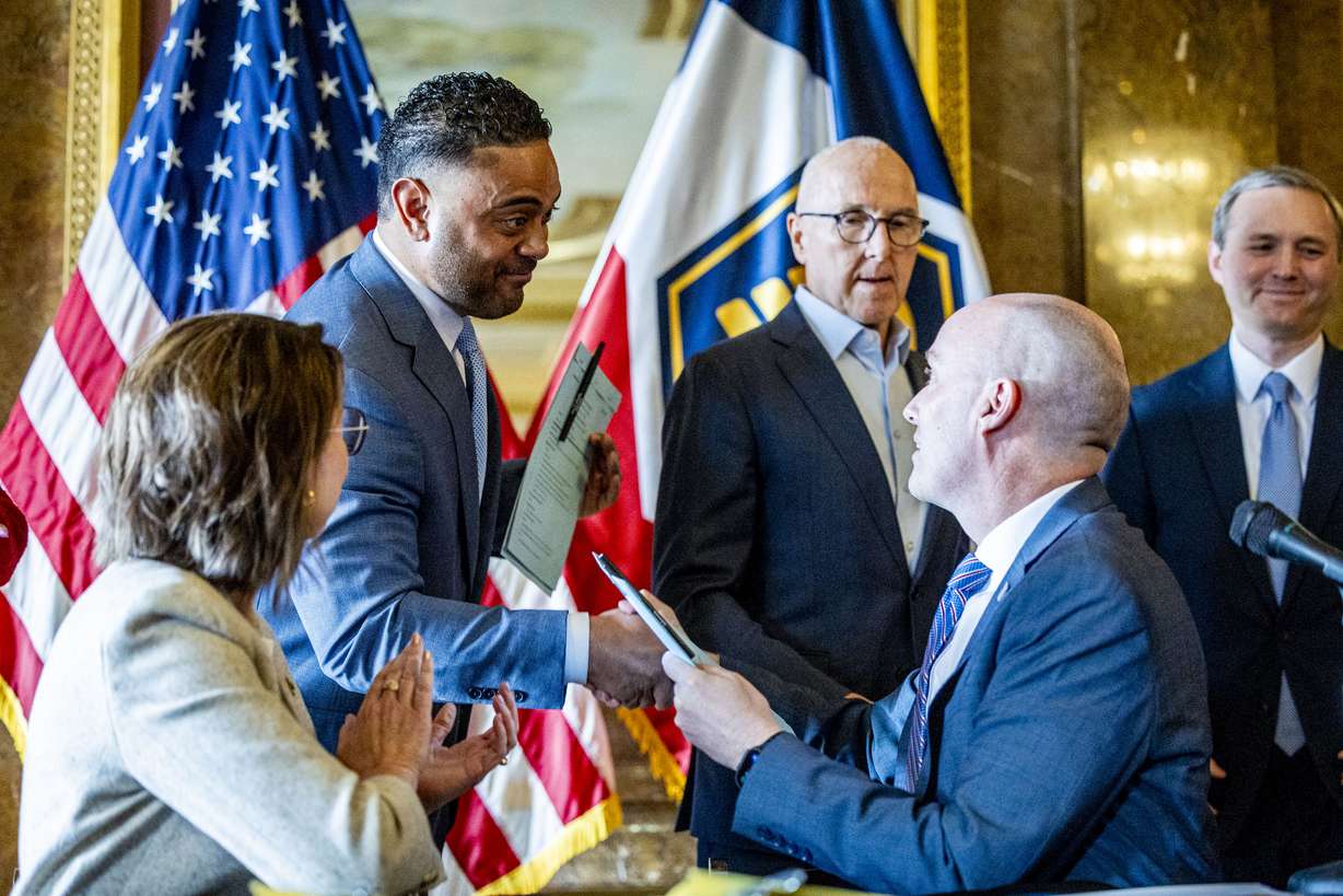 Utah Gov. Spencer Cox shakes hands with Rep. Doug Fiefia, R-Herriman, after signing a ceremonial copy of HB418, at the Capitol April 4.