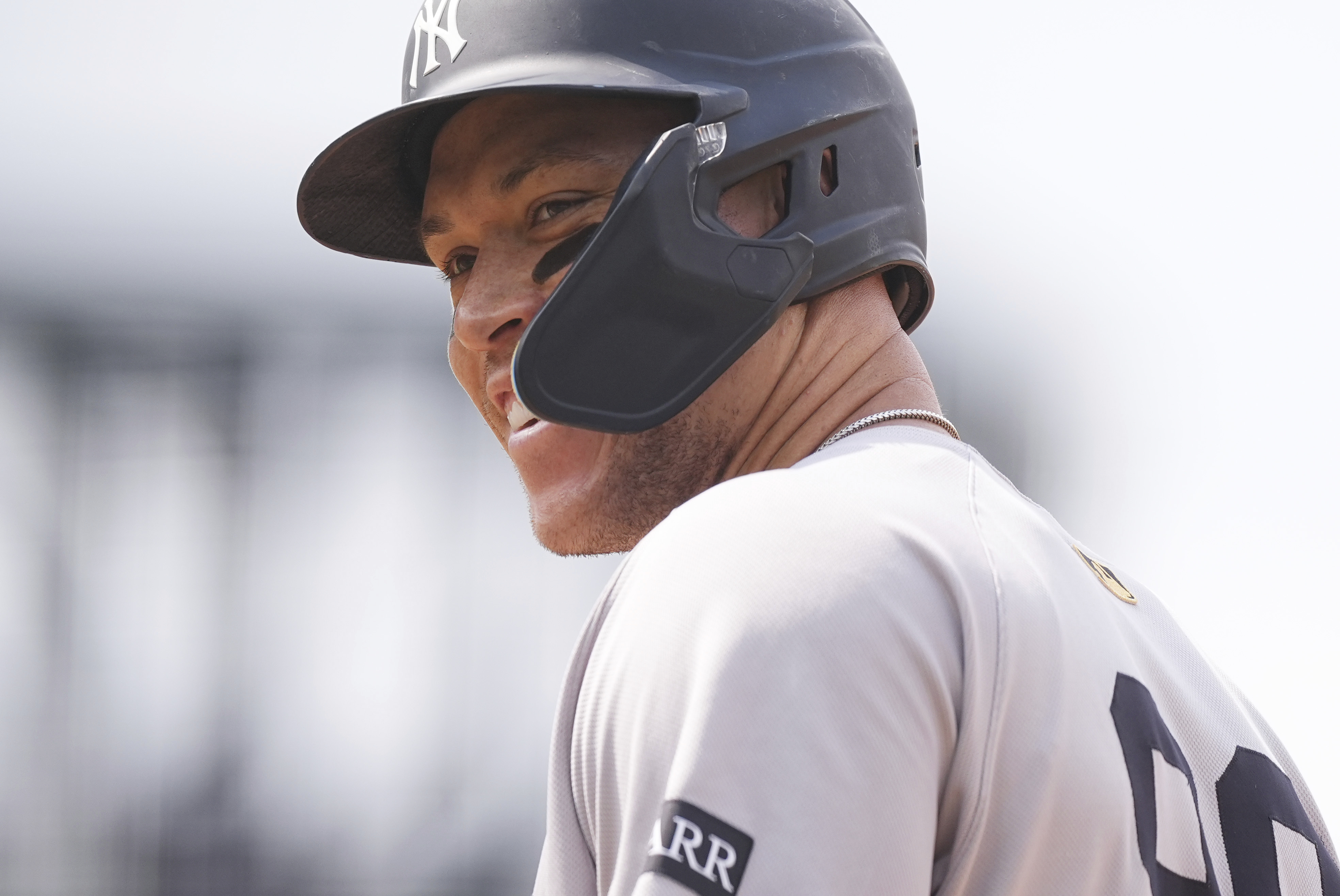 New York Yankees' Aaron Judge smiles as he steps on first base after being issued an intentional walk in the fifth inning of a baseball game against the Colorado Rockies, Saturday, May 24, 2025, in Denver.