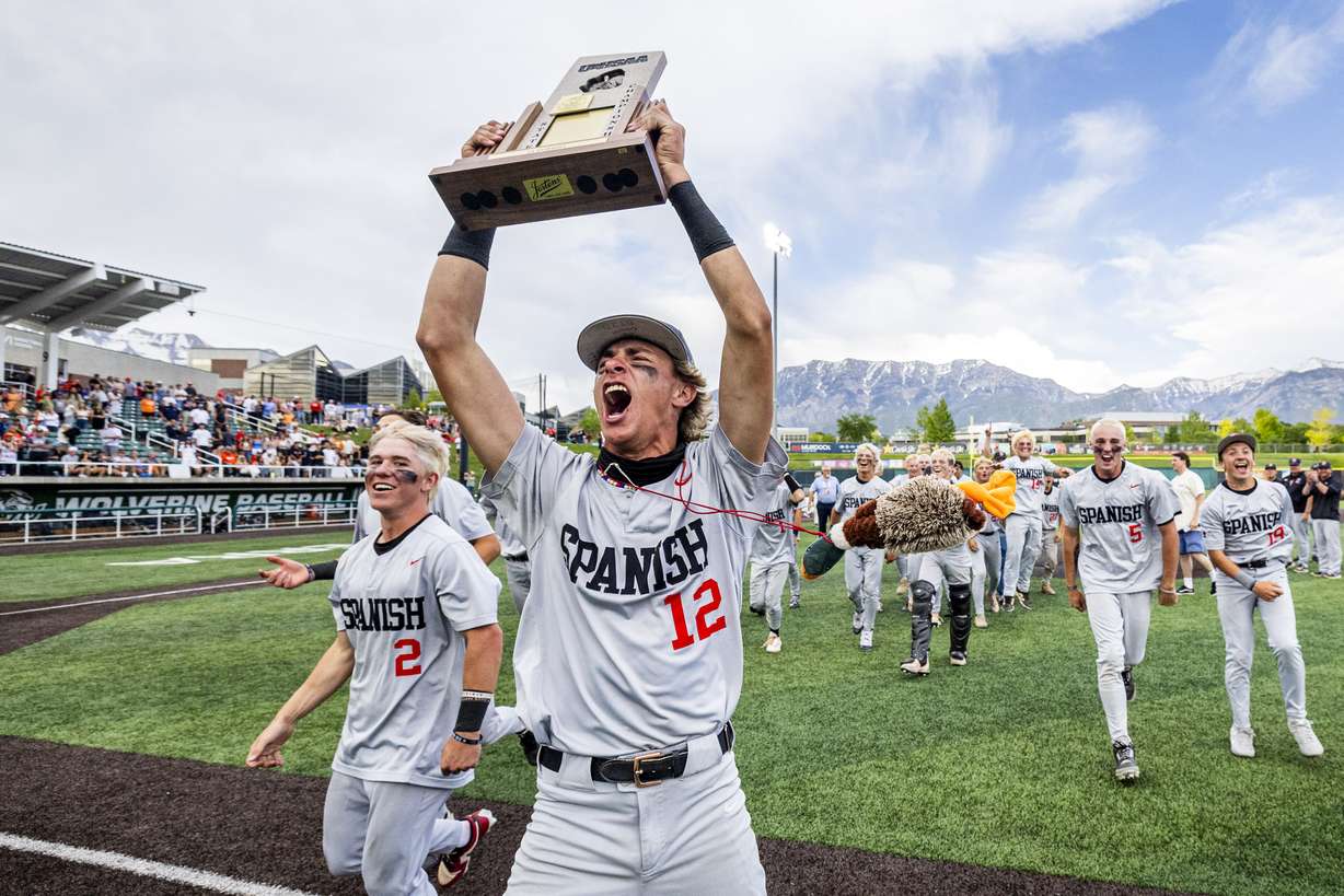Spanish Fork outfielder Jackie Sorenson (12) hoists up the championship trophy as he celebrates with his teammates after the Dons defeated Brighton 7-4 during the final game of the championship series in the 5A high school baseball state tournament held at UCCU Ballpark on the campus of Utah Valley University in Orem on Saturday, May 24, 2025.