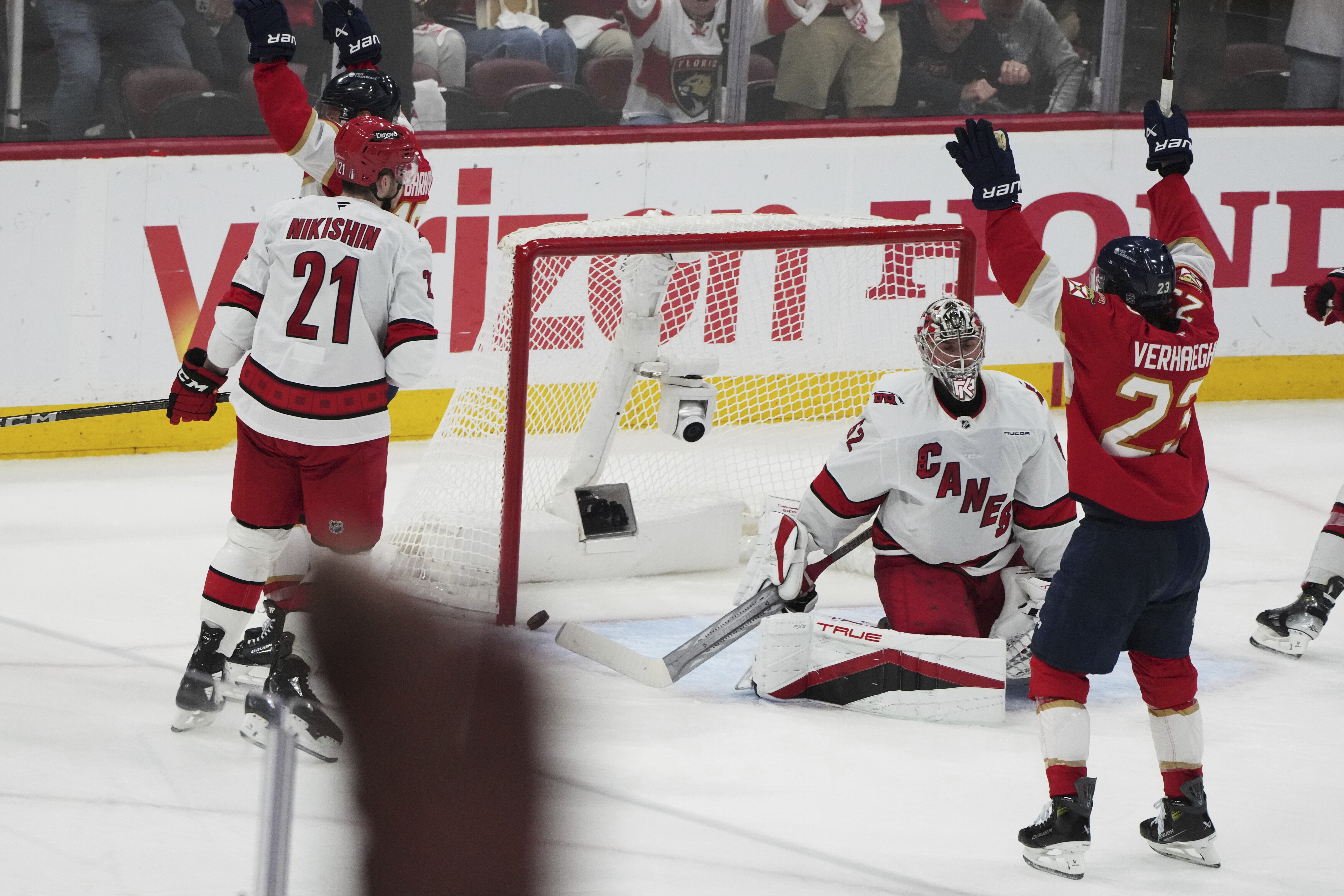 The puck gets past Carolina Hurricanes goaltender Pyotr Kochetkov, center, on a goal scored by Florida Panthers' Aleksander Barkov during the third period in Game 3 of the NHL hockey Stanley Cup Eastern Conference finals Saturday, May 24, 2025, in Sunrise, Fla.