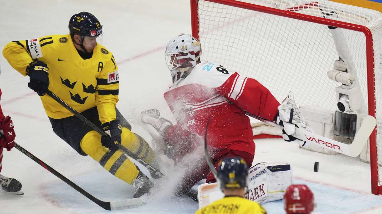 Sweden's Mikael Backlund in action in front of Denmark's Frederik Dichow during the bronze medal match between Denmark and Sweden at the ice hockey world championships in Stockholm, Sweden, Sunday, May 25, 2025.