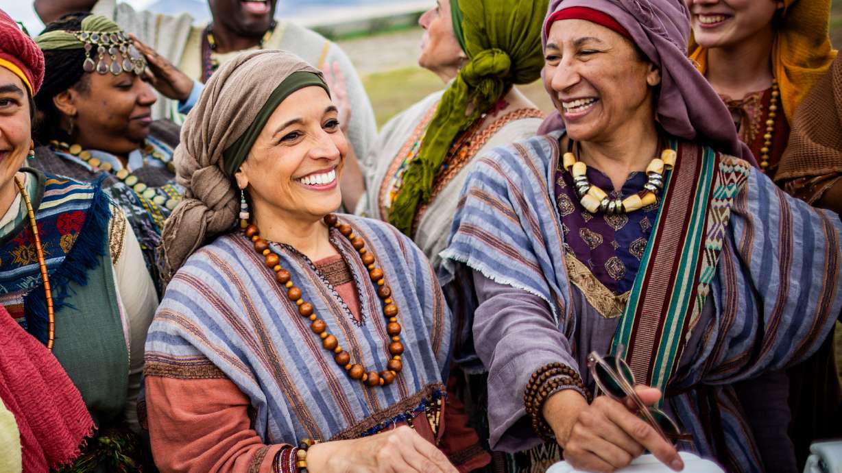 Paid background actors, part of the teal group, laugh after posing for a group photo on the set of "The Chosen" in Goshen, Utah County, on Tuesday, May 14, 2025.