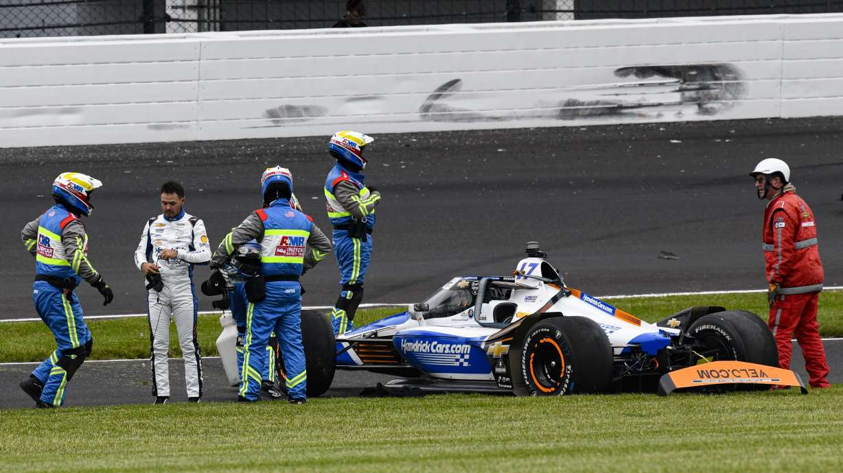 Kyle Larson, second from left, is checked after he hit the wall in the second turn during Indianapolis 500 auto race at Indianapolis Motor Speedway in Indianapolis, Sunday, May 25, 2025.
