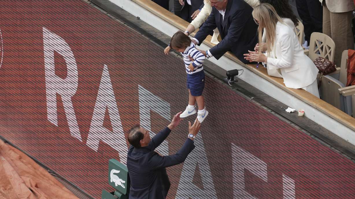 Rafa Nadal reaches for his son Rafael Junior during a farewell ceremony at center court Philippe-Chatrier, at the Roland-Garros stadium, in Paris, Sunday May 25, 2025.